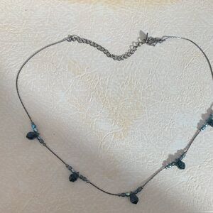 Crystal beads interspersed on gunmetal gray.  Maker stamp on tag is unidentified